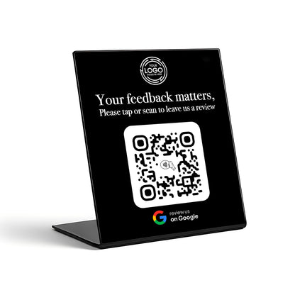 a black sign with a QR code on it, along with instructions for leaving a review.