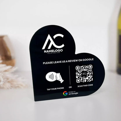 a black sign with a heart shape and text, along with a QR code and a button for a review on Google.